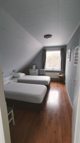 a bedroom with two beds and a window at Vakantiehuis Horsterwold in Zeewolde