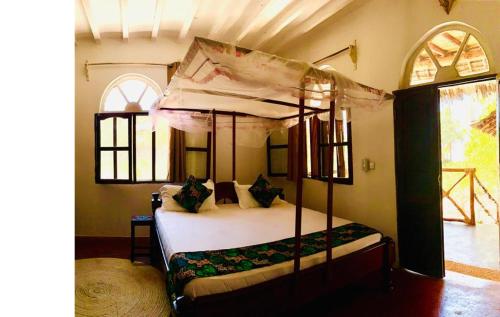 una camera con letto a baldacchino di Lazy Beach House a Kiwengwa