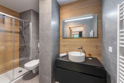 a bathroom with a sink and a toilet and a mirror at Quintessence - Apt A201 - BO Immobilier in Châtel