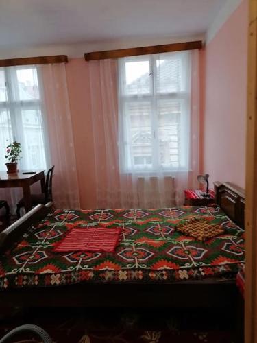 - une chambre avec un lit et une couverture à motifs dans l'établissement La 2 pași de Biserica Neagră, à Braşov