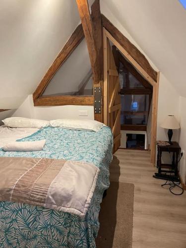 a bedroom with a bed in a room with an attic at Duplex à la campagne in Vermenton