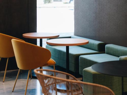 a group of tables and chairs in a room at Prince Smart Inn Miyazaki in Miyazaki