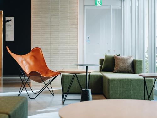 a living room with a couch and a table and chairs at Prince Smart Inn Miyazaki in Miyazaki