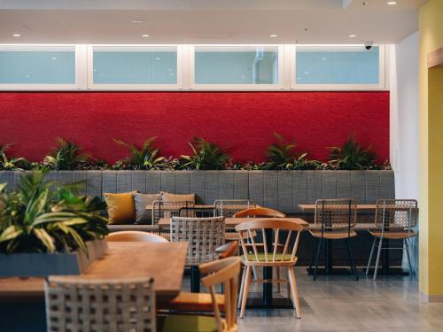 a restaurant with tables and chairs and a red wall at Prince Smart Inn Miyazaki in Miyazaki