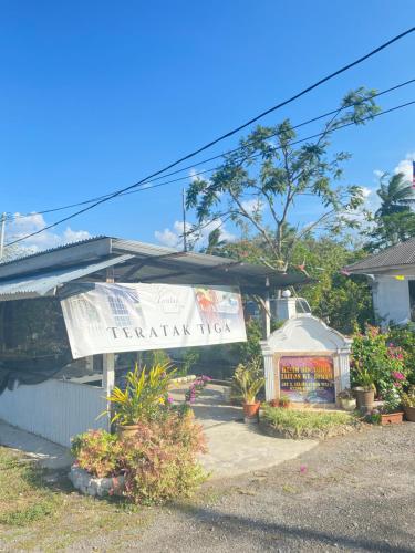 a house with a banner on the front of it at Teratak Tiga Homestay Padang Besar in Kaki Bukit