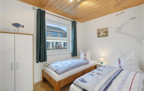 een slaapkamer met 2 bedden en een raam bij Ferienhaus 41 Altefhr in Altefähr