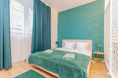 1 dormitorio con 1 cama grande con manta verde en RothApartments'ALICE, en Budapest