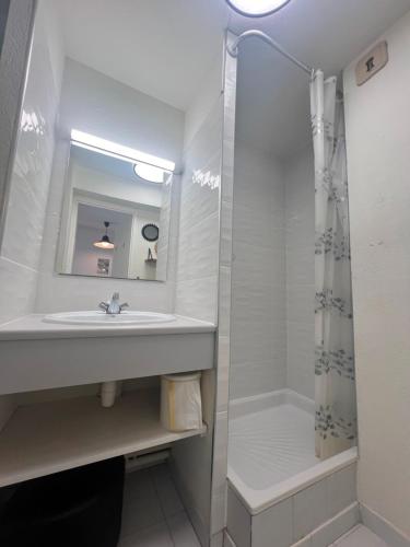 une salle de bain blanche avec un lavabo et une douche dans l'établissement SAVANNA BEACH I Joli 2 pièces cabine vue mer piscine Rochelongue Cap d'Agde, au Cap d'Agde