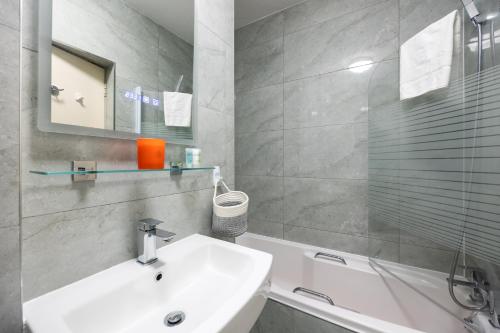 een badkamer met een wastafel, een bad en een spiegel bij Fantastic 2BD apt in THE best location in Dublin in Dublin
