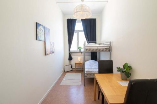 a living room with a table and a bunk bed at Dalasjö vandrarhem in Vilhelmina