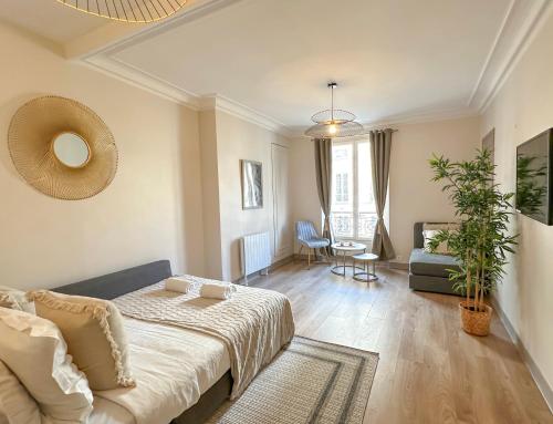 un soggiorno con letto e divano di Champs Elysées area - Deluxe Family Apartments a Parigi
