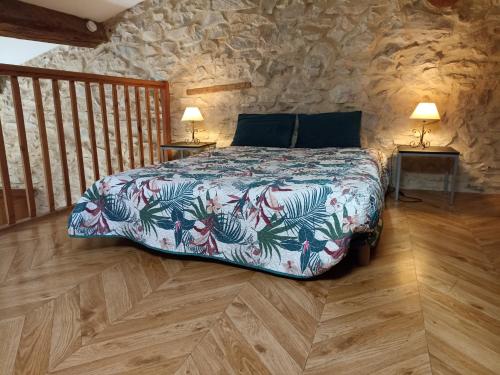 a bedroom with a bed in a stone wall at Mas des Esclots in Nîmes