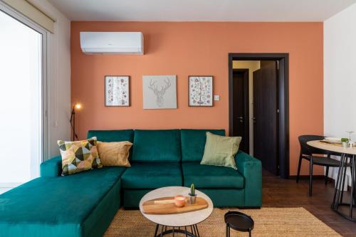 a living room with a green couch and a table at Harbor Apartments in Larnaca in Larnaka