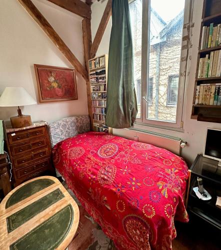 a bedroom with a red bed and a window at Charmant Duplex calme 40m 2 in Paris