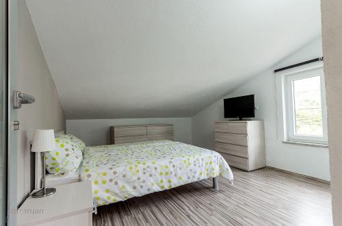 ein Schlafzimmer mit einem Bett und einem TV in der Unterkunft Strandnahes Apartment mit Pool, Whirlpool in Klenovica