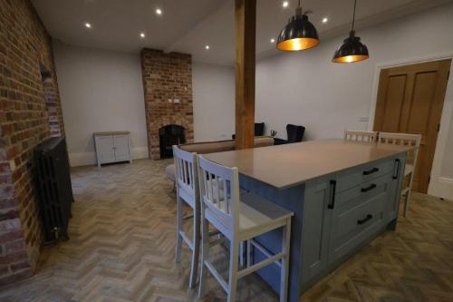 a kitchen with a counter and chairs in a room at Red Lion Apartments in Spalding