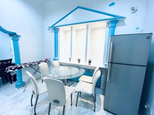 a kitchen with a table and chairs and a refrigerator at SingHome Holiday House in Mersing