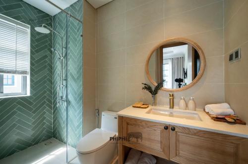 a bathroom with a toilet and a sink and a mirror at La Mer Villa in Bình Tú