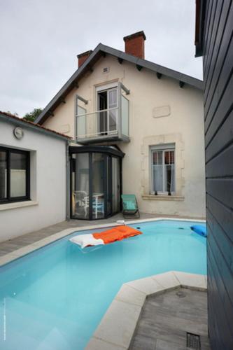 une grande piscine bleue devant une maison dans l'établissement Villa Maurice avec piscine centre La Rochelle, à La Rochelle