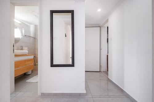a white bathroom with a mirror on a wall at LuxuryApt/BestView/PerfectForFamilies/FreeParking in Eilat