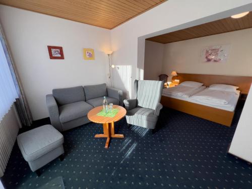 a hotel room with a bed and a couch and a table at Hotel Haus Christel in Willingen