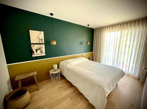 une chambre avec un lit et un mur végétal dans l'établissement Vue mer La Baule : Le Carina, à La Baule