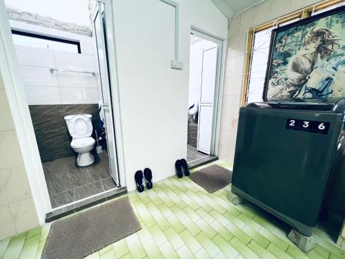 een badkamer met een toilet en een douchecabine bij SingHome Holiday House in Mersing