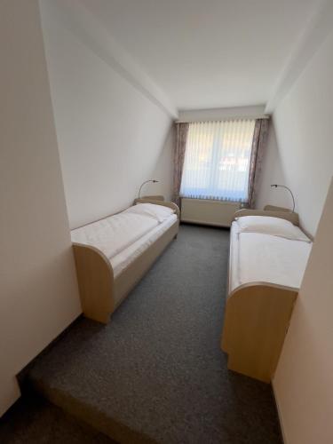 a small room with two beds and a window at Hotel Haus Christel in Willingen