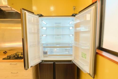 an empty refrigerator with its door open in a kitchen at Ryokan -Suikoen- in Yugawara