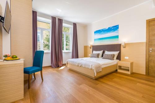 a bedroom with a bed and a blue chair at Nur 140 Meter zum Strand mit Pool in Crikvenica