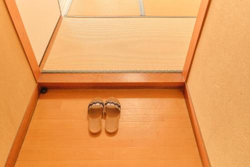a pair of shoes on the floor of a room at Ryokan -Suikoen- in Yugawara