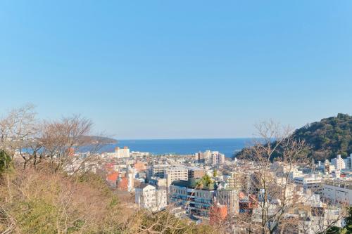 a view of a city with the ocean in the background at Ryokan -Suikoen- in Yugawara