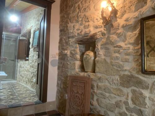 uma casa de banho com uma parede de pedra e um lavatório. em Casa tipica sarda 