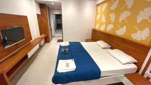 a small room with a bed with a tv and a bed sidx sidx at Hotel Ambai Executive in Tuljapur