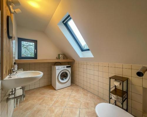 a bathroom with a washing machine and a sink at Moor Feeling Apartments Worpswede in Worpswede