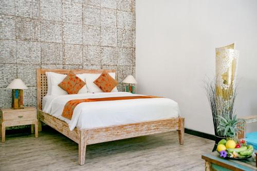 1 dormitorio con 1 cama con sábanas blancas y almohadas de color naranja en Kura Kura Resort Gili Meno, en Gili Meno