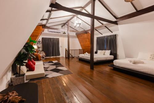 a room with two beds in a room with wooden floors at 60s Town in Hua Hin