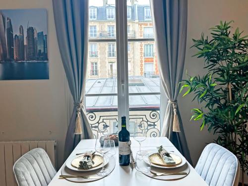 un tavolo con un piatto di cibo e una bottiglia di vino di Champs Elysées area - Deluxe Family Apartments a Parigi