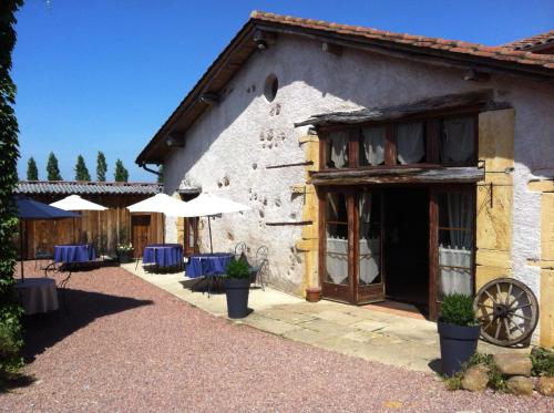 a building with chairs and umbrellas in a courtyard at La Grange in Coutouvre