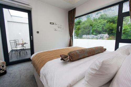 Schlafzimmer mit einem Bett und einem großen Fenster in der Unterkunft Exklusive Privatvilla in wunderbarer Natur in Antovo