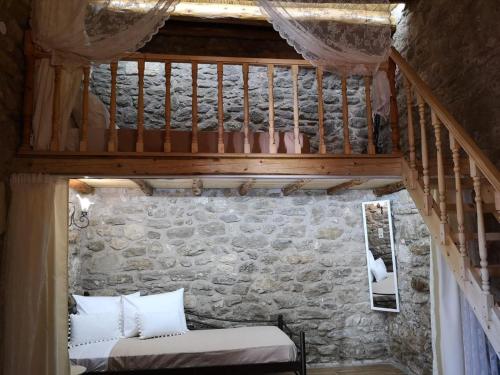 a room with a bed in a stone wall at M&M STONE-Village House-Family-Vintage in Lindos