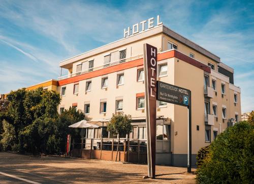 ein Hotelgebäude mit einem Schild davor in der Unterkunft Gartenstadt Hotel in Ludwigshafen am Rhein