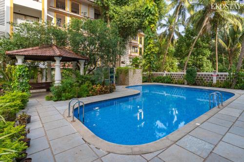 a swimming pool in a yard with a gazebo at EKO STAY - Woodlock Apartment in Candolim