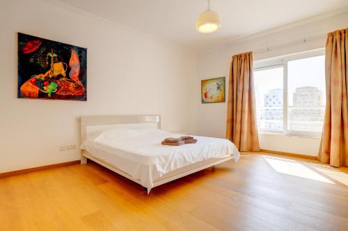 a bedroom with a bed and a painting on the wall at Seafront Apartment Sliema in Sliema