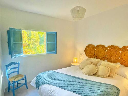 a bedroom with a bed and a chair and a window at Resort El Paraíso Secreto in Miller