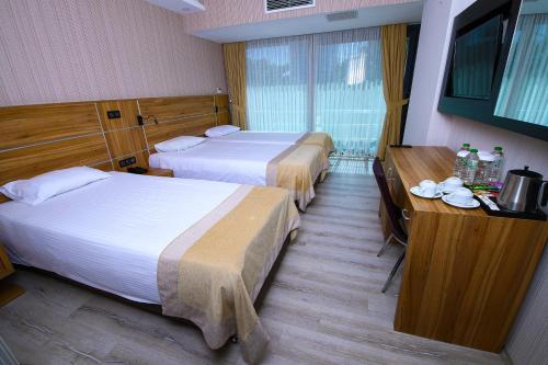 a hotel room with two beds and a desk at VOLLEY HOTEL ANKARA in Ankara