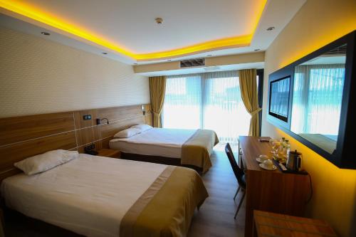um quarto de hotel com duas camas e uma televisão em VOLLEY HOTEL ANKARA em Ancara