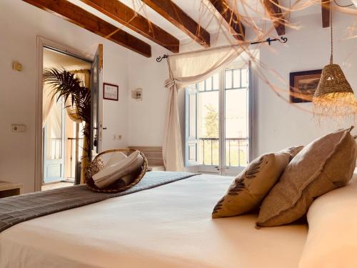 Un dormitorio con una cama grande con almohadas. en Casal d'Artà by Baudot 1926 - Adults Only, en Artà