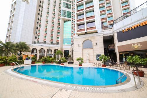 a large swimming pool in front of a building at Hotel The Royal Plaza in New Delhi