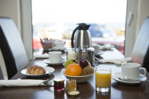a table with a plate of food and a glass of orange juice at Ellan Vannin Hotel in Douglas